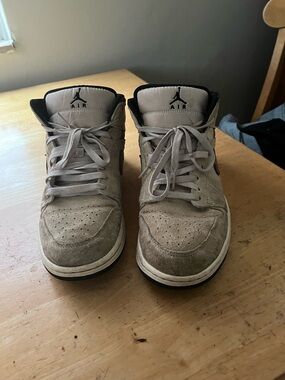 Nike Air Jordan 1 Mid shoes featuring a grey suede upper